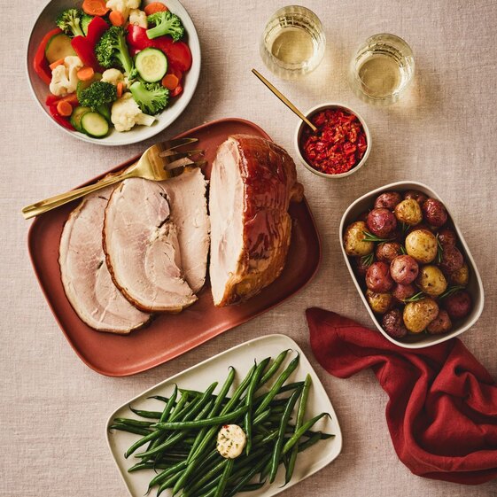 Sliced porchetta roast with rosemary potatoes, green beans and vegetables, festive holiday dinner meal kit.